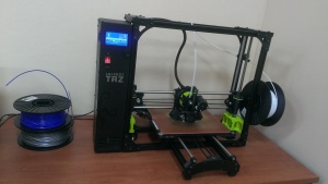 imagen de una impresora 3d y su carrete de filamento